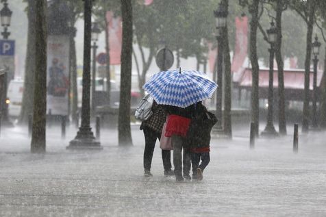 528338-des-personnes-affrontent-un-orage-le-17-juin-2013-sur-les-champs-elysees-a-paris